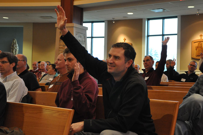 Amos Stinson, left, and Paul Burke, parishioners of St. Patrick Church, raised their hands in response to a question from Archbishop Joseph E. Kurtz at the Catholic Men’s Conference March 5. (Record Photo by Jessica Able)