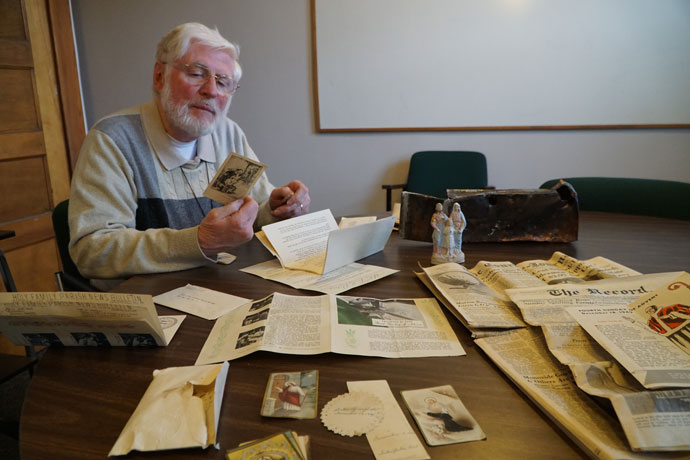 Deacon Patrick Wright, administrator of Holy Family Church, inspected a Mass card depicting the Holy Family on Feb. 24. The card and other items were enclosed in a time capsule from 1949, which was discovered during the demolition of the former Holy Family Convent on Poplar Level Road. (Record Photo by Jessica Able)