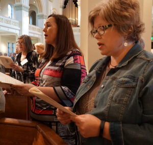Women from St. Patrick Church in Louisville, above foreground from left, Jonna O'Bryan and carrie Williamson, sang during the closing liturgy of the "Women of the Church" conference Oct. 8.