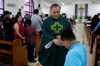 Msgr. James Benavente blesses a boy after Mass at Santa Barbara Church on the island of Guam Aug. 13. (CNS photo/Erik De Castro, Reuters) See GUAM-NORTH-KOREA-PRAYERS Aug. 14, 2017.