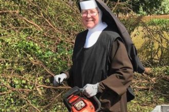 Carmelite Sister Margaret Ann Laechelin, principal of Archbishop Coleman F. Carroll High School in Miami, holds the chainsaw she used to help clean up debris following Hurricane Irma. (CNS photo/courtesy Sister Margaret Ann)