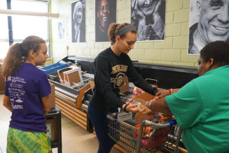 Rebecca Lee, left, an eighth-grader at St. Joseph School in Bardstown, Ky., and Lauren Lee, a junior at Bethlehem High School in Bardstown, assisted a client at the Bread for Life community food pantry on Oct. 7. Students from Bethlehem staff and manage the food pantry on Saturdays. (Record Photo by Jessica Able)