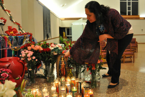 La Sra. Magdalena Gomez coloca una estatua de la Virgen de Guadalupe cerca del altar en la parroquia St. Edward durante la celebración parroquial de la Virgen de Guadalupe el día 12 de diciembre.