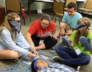 Teenagers, from left to right, Kimberly Malone, Kacie Gaekle, Jack Wolfram and Tessa Grissom and Jason Patrana, foreground, worked together to assemble a puzzle during a team-building activity at the annual Christian Leadership Institute held July 6 to 10 at the Flaget Center. (2015 Record File Photo)