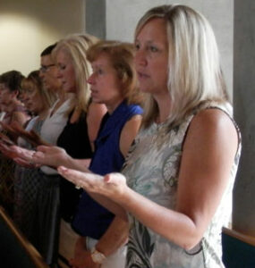 Teachers saying the Lord's Prayer during the annual Mass for educators held this year at St. Margaret Mary Church, 7813 Shelbyville Road, on Aug. 10.