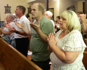 Parishioners of St. John Chrysostom Church in Eminence, Ky., prayed the Lord’s Prayer during a Mass celebrated by Archbishop Joseph E. Kurtz Aug. 9 to consecrate a new altar. The new altar is part of a major renovation at the small parish. Record Photo by Marnie McAllister