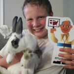 ‘Flat Francis’  at St.  Leonard Archbishop Joseph E. Kurtz, above, met with students at St. Leonard School Sept. 10 to hear about their participation in the #flatfrancis project. In preparation for Pope Francis’ visit to the U.S., students are taking part in the social media campaign sponsored by Catholic Extension. Students, such as Kobe Bridwell, right, take selfies with a cut-out image of Pope Francis, similar to the children’s book “Flat Stanley.”  Photos Special to The Record
