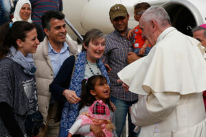 Pope Francis greeted Syrian refugees he brought to Rome from the Greek island of Lesbos, at Ciampino airport in Rome April 16. The pope concluded his one-day visit to Greece by bringing 12 Syrian refugees to Italy aboard his flight. (CNS Photo by Paul Haring)
