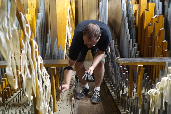 Daniel Schwandt, an organist from Chicago, Ill., worked to remove small pipes from the swell division of the organ at St. Martin of Tours Church, 639 South Shelby St., July 7. More than 700 pipes were removed and taken to Wahl Organbuilders in Appleton, Wis., where they will be restored. After six months of work, the pipes will be re-installed next January. (Record Photo by Ruby Thomas)