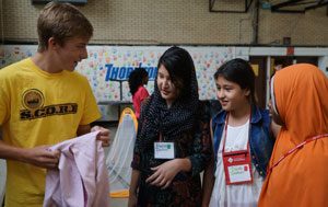 Andrew Klem handed out used clothing to refugee children during the S.C.O.R.E soccer clinic July 18 (Record Photo by Ruby Thomas)