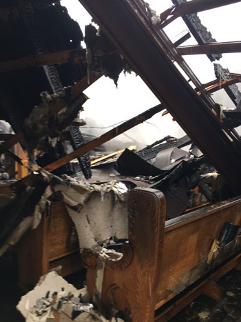 Sections of the roof and beams rest on pews in Our Lady of the Caves Church in Horse Cave, Ky. The church building suffered a fire Dec. 9.