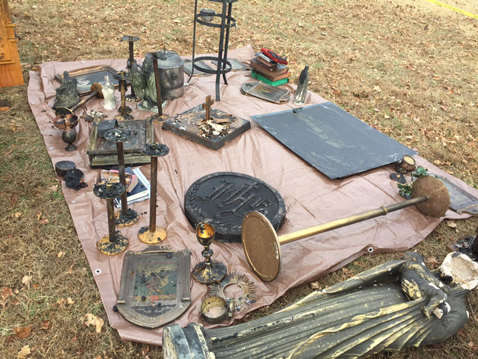 Fire damaged candle sticks, statues and other liturgical items are seen on the ground next to Our Lady of the Caves Church in Horse Cave, Ky. The church building caught fire early Dec. 9.
