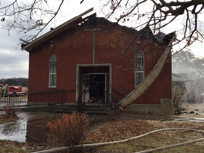 Fire damage can be seen to the roof and front of Our Lady of the Caves Church in Horse Cave, Ky., Dec. 9.