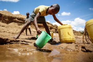 A boy collects water in a dry riverbed in Kitui, Kenya, in this 2015 file photo. (CNS photo/Dai Kurokawa, EPA)
