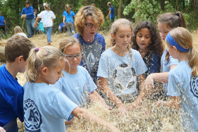 Kelley Schleg, a fourth-grade teacher at St. Agnes School, 1800 Newburg Road, helped a group of students spread straw on one of the newly-created wetlands located on the campus of the The Passionist Earth and Spirit Center. (Record Photo by Ruby Thomas)